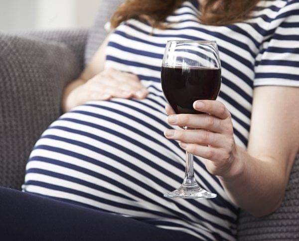 Alcohol and Pregnancy Close Up Of Pregnant Woman Drinking Red Wine